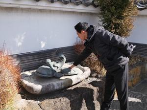 巴波川沿いのなまずモニュメントに触れる市長
