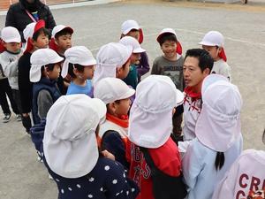 跪いて子供達と同じ目線で話をする市長