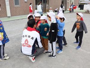 跪いて子供達と同じ目線で話をする市長