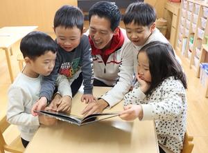 給食後に子供達と一緒に絵本を読む市長