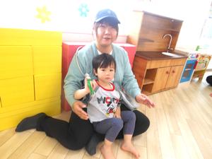 音楽に合わせて鈴を鳴らしている、応援隊参加してくれた親子の写真