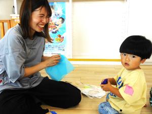 工作でお花紙を丸めている男の子とそのママの写真