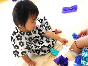 くつろいだ格好でテープをはがす女の子の写真