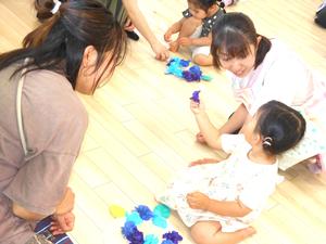 丸めたお花紙を先生に見せている女の子の様子