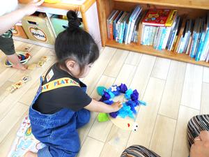 工作でカタツムリの背中に丸めたお花紙を付ける女の子の様子