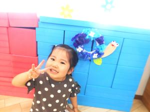 完成した作品を飾って、ポーズをとる女の子の写真
