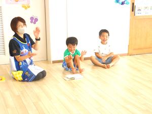 2人の幼稚園児が保育士と手遊びをしている様子