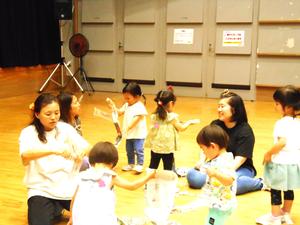新聞紙をちぎったり丸めたりしている先生とお友だちの様子