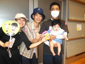 紙飛行機飛ばし競争で優勝した親子の記念写真