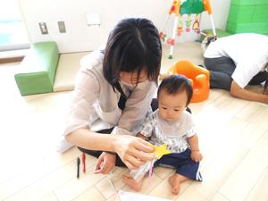 短冊にお願い事を書いて、赤ちゃんに見せるママの様子