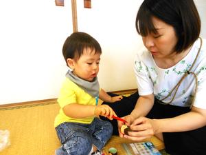 七夕飾りの織姫と彦星の顔を描いている親子の様子