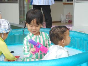 プールの中に入り、座って遊ぶ姉弟の様子