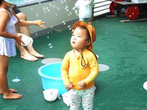 いっぱいのしゃぼん玉にうっとりしている男の子の写真