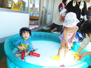 プールの中で水鉄砲を楽しむ男の子と女の子の様子