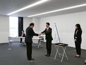 辞令交付式にて退職辞令を交付する市長