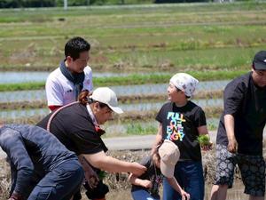 子供と一緒に田植えをする市長