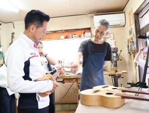 ウクレレを持ち高山さんの説明を受ける市長