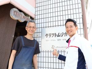 お店の看板の前で高山さんと記念撮影をする市長