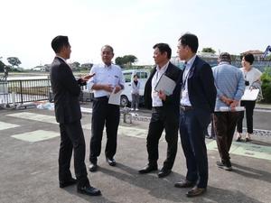 視察先で菊池会長と話をする市長と職員