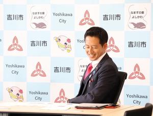 職員の説明を笑顔で聞く市長