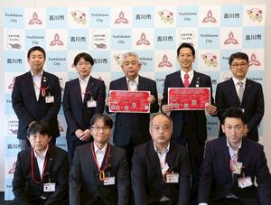 吉川市のバックパネルを背に市長と郵便局長の皆さんとの記念撮影