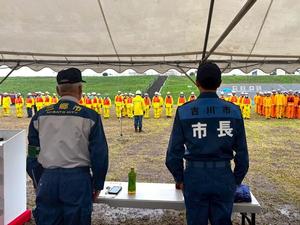 整列する水防団を直立で見守る市長