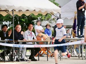 ゴールテープを切ろうとする児童を笑顔で応援する市長