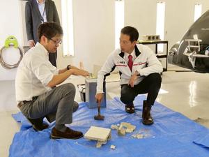 塗装の耐久確認のため、塗装したブロックをハンマーで叩いた市長