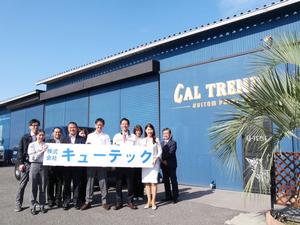 社外でキューテックの看板をみんなでもって記念撮影