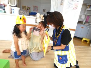 紙芝居の読み聞かせで、誕生児にケーキを見せている様子