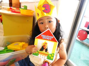 プレゼントの冠を被って誕生日カードを見せてくれた誕生児の女の子の写真