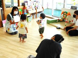 絵本を読む保育士に近づいていく子どもの様子