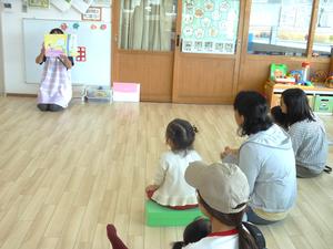 紙芝居の読み聞かせを見ている親子たちの様子