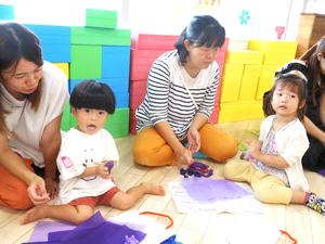 お花紙を丸めるカメラ目線の男の子と女の子の様子