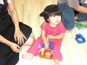 丸めたお花紙を袋に詰める女の子の写真