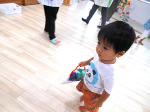 完成した作品（ぶどうを入れたバッグ）を持ってお散歩する男の子の写真