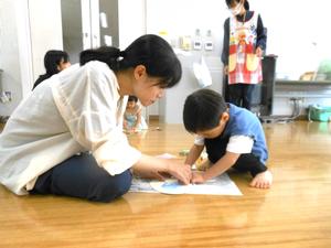 おじいちゃんおばあちゃんにプレゼントするうちわを作っている親子の様子
