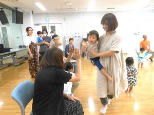 ママに抱っこされて、おじいちゃんおばあちゃんとハイタッチして回る男の子の様子
