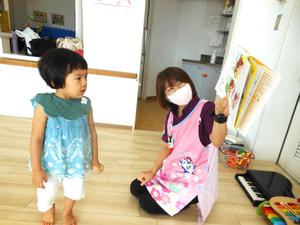 ノンタンの絵本の読み聞かせを間近で見ている女の子の様子
