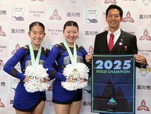 チアリーディングのユニフォームで細井さん、吉岡さんと市長とで記念撮影