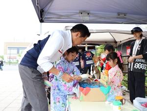 浴衣を着た小さい女の子と話をする市長