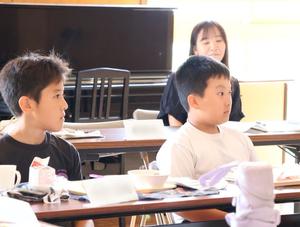 真剣な表情で市長の説明を聞く児童たち