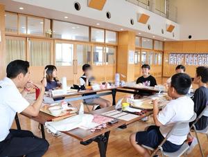 笑顔でランチミーティングで話す児童