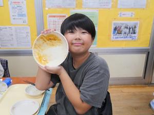 からっぽの器を見せる笑顔の児童