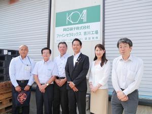 屋外の会社看板の前で記念撮影