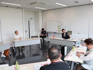 写真を手に説明する市長