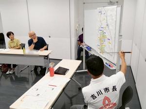 市域図を指示棒で指して説明する市長