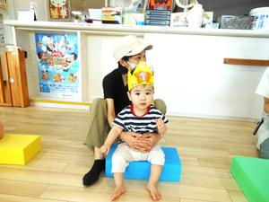 冠を被りカラー積み木に座っている誕生児の写真