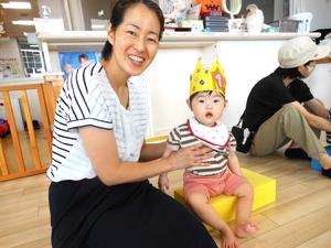 冠を被ている誕生児の女の子とママのカメラ目線写真