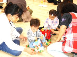 講座中の同室託児で、保育ボランティアさんとおもちゃで遊ぶ2名の子どもの様子